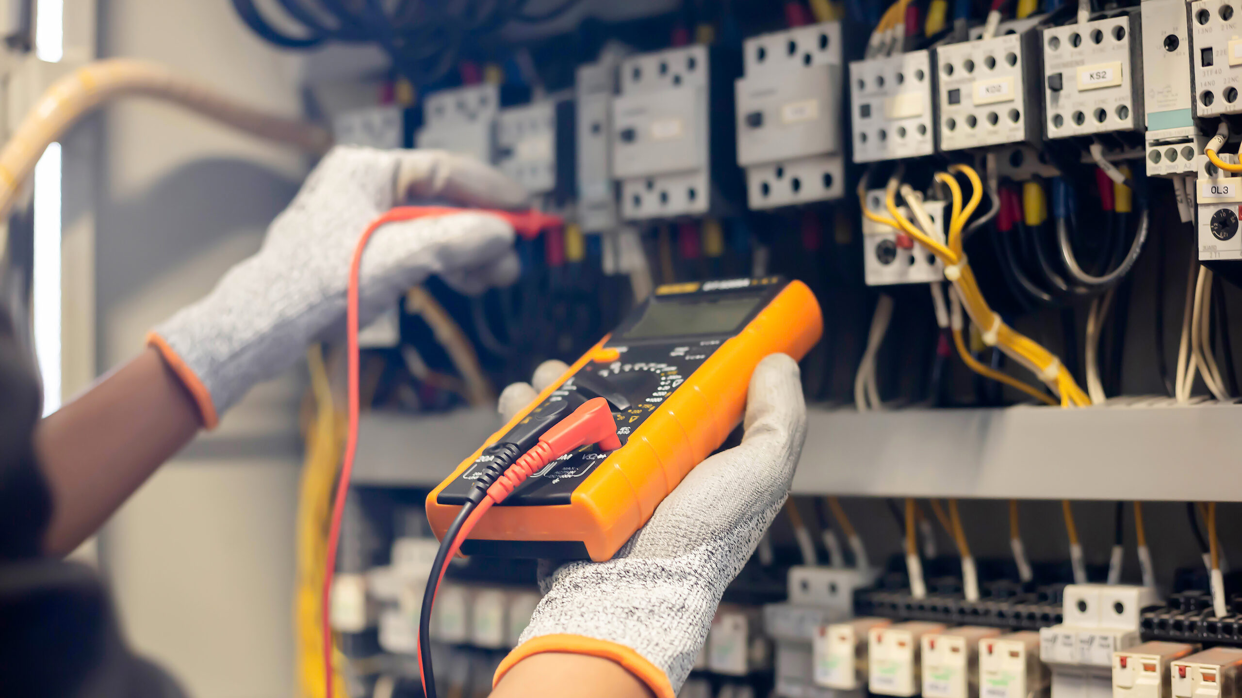 S Clark electrician using multimeter to test electricity